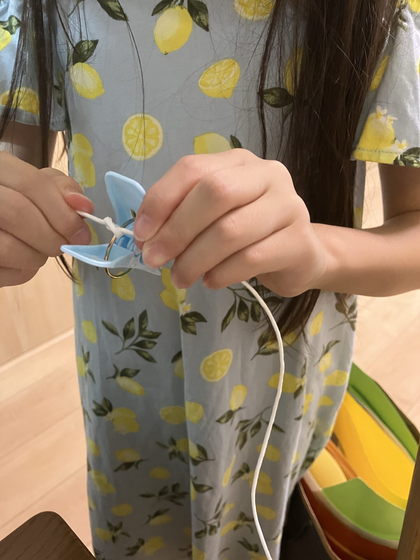 子供が洗濯バサミに紐を結びつける
