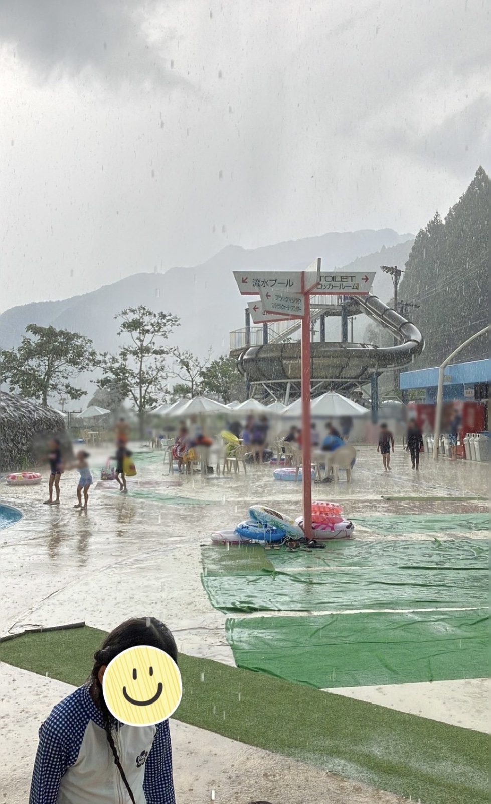 プールサイドでゲリラ豪雨にうたれ避難する人々